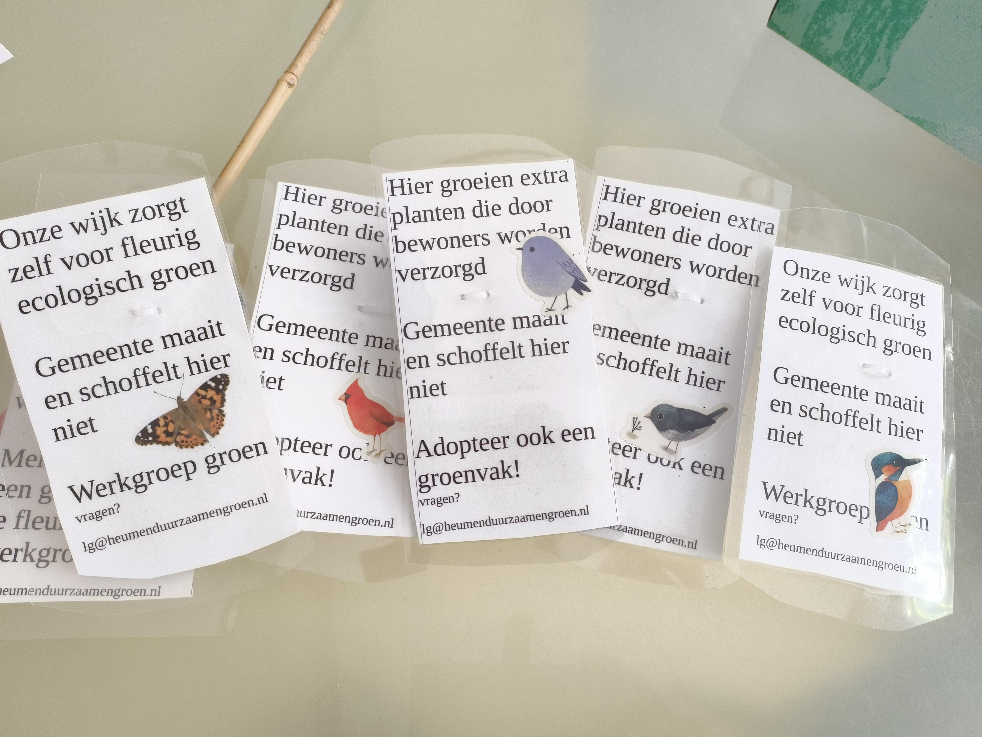 Zelfgemaakte geplastificeerde bordjes met stickers van vogels waarop staat
Deze wijk zorgt zelf voor fleurig groen
Gemeente maait en schoffelt hier niet

En meer dit soort trjstrn