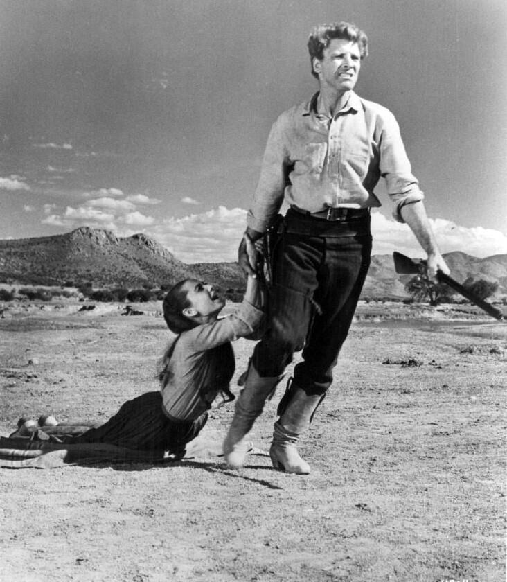 Burt Lancaster drags Audrey through the dust, in The Unforgiven.